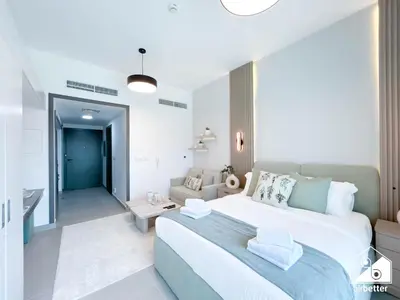 a bedroom with a large bed and a living room at High-End Studio l Pool & Gym Included in Dubai