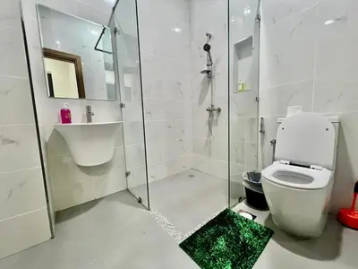 a bathroom with a shower and a toilet and a sink at Karama Palace Home in Dubai