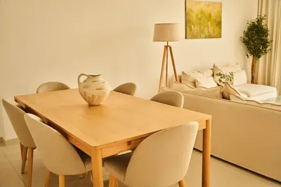 a dining room table with chairs and a vase on it at Luxury 58th Floor Seaview 2BR - Paramount Midtown - 6 Guests - 64F Pool Access & Burj View in Dubai