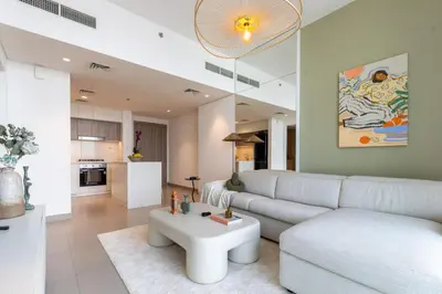 a living room with a white couch and a table at Hills Parkhouse - Pool Gym Parks Mall and Burj Khalifa View in Dubai