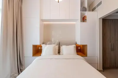 a bedroom with a large white bed with white pillows at Hills Parkhouse - Pool Gym Parks Mall and Burj Khalifa View in Dubai