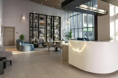a lobby with a waiting area with chairs and a table at Hills Parkhouse - Pool Gym Parks Mall and Burj Khalifa View in Dubai
