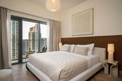 a bedroom with a large white bed and a large window at Seraya Residences at Burj Royale in Dubai