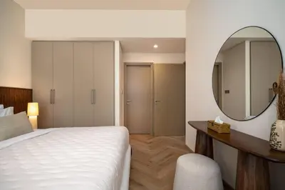 a bedroom with a bed and a mirror and a desk at Seraya Residences at Burj Royale in Dubai