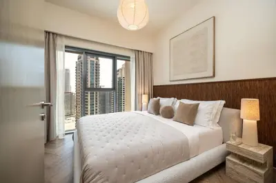 a bedroom with a large bed and a large window at Seraya Residences at Burj Royale in Dubai