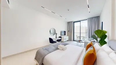 a living room with a white couch and a table at Dusk By Binghatti - Dazzling Studio in JVC in Dubai