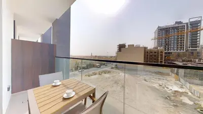 a balcony with a table and a view of a city at Dusk By Binghatti - Dazzling Studio in JVC in Dubai