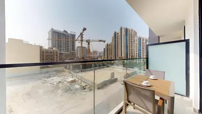 a balcony with a view of a construction site at Dusk By Binghatti - Dazzling Studio in JVC in Dubai