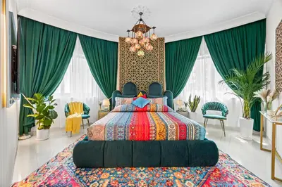 a bedroom with a large bed and green curtains at 1BR Full Burj View 1 min to Dubai Mall Arabic Vibe in Dubai