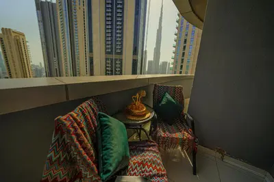 a balcony with two chairs and a table and buildings at 1BR Full Burj View 1 min to Dubai Mall Arabic Vibe in Dubai
