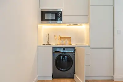 a kitchen with a washing machine and a microwave at Cozy Marina Studio, Canal View with a Balcony in Dubai