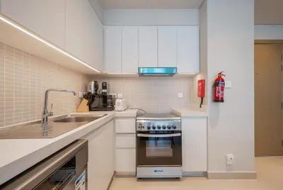 a white kitchen with a sink and a stove at Luxurious 1BR Apartment in Harbour Gate in Dubai
