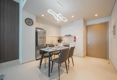 a kitchen with a table and chairs and a refrigerator at Luxurious 1BR Apartment in Harbour Gate in Dubai