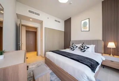 a bedroom with a large bed and a desk at Luxurious 1BR Apartment in Harbour Gate in Dubai