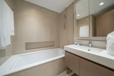a bathroom with a bath tub and a sink at Luxurious 1BR Apartment in Harbour Gate in Dubai