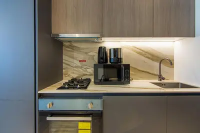 a kitchen with a microwave and a coffee maker on the counter at Brand New Studio with Pool View in The Grove by Iman, Dubai Hills in Dubai