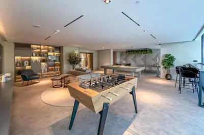 a living room with a foosball table in the middle at Brand New Studio with Pool View in The Grove by Iman, Dubai Hills in Dubai