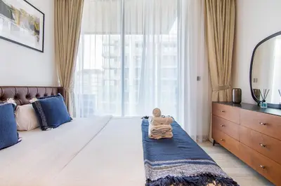 a bedroom with a bed with a doll sitting on it at Brand New Studio with Pool View in The Grove by Iman, Dubai Hills in Dubai