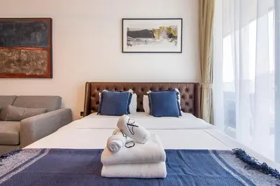 a bedroom with a bed with towels on it at Brand New Studio with Pool View in The Grove by Iman, Dubai Hills in Dubai