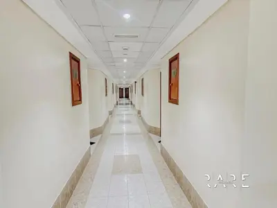 a hallway with white walls and paintings on the walls at Rare Holiday Homes - Near City Center Ma'eisem - Lake view - Crescent Tower C - R806 - IMPZ in Dubai