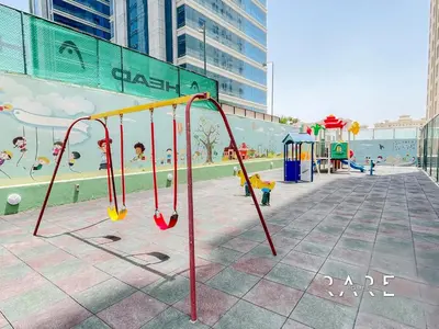a playground in a city with a play area at Rare Holiday Homes - Near City Center Ma'eisem - Lake view - Crescent Tower C - R806 - IMPZ in Dubai