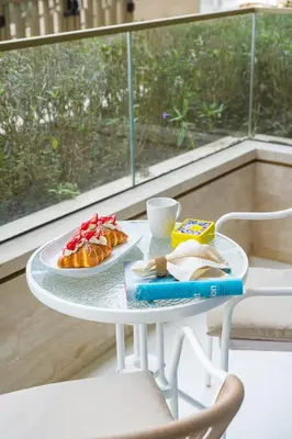 a white table with a plate of food on it at Airstay - Minimalist 1BR - EMAAR Beachfront - Monthly Offer Available in Dubai