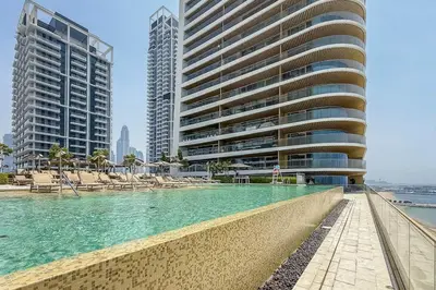 a swimming pool in the middle of two tall buildings at Airstay - Minimalist 1BR - EMAAR Beachfront - Monthly Offer Available in Dubai