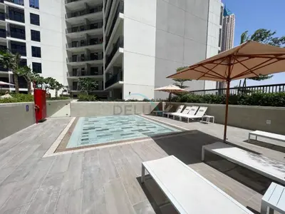 a patio with benches and an umbrella and a pool at Facing the Dubai Water Canal 1BR, Minutes from Metro with Easy Downtown Access, Zada Tower, Business Bay by Deluxe Holiday Homes in Dubai