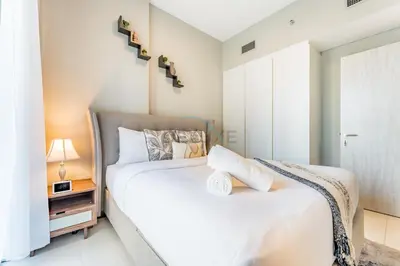 a bedroom with a large white bed and a window at Facing the Dubai Water Canal 1BR, Minutes from Metro with Easy Downtown Access, Zada Tower, Business Bay by Deluxe Holiday Homes in Dubai