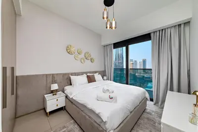 a bedroom with a bed and a large window at Burj View Stylish 3BR with Maids Room in Act One Tower Downtown in Dubai