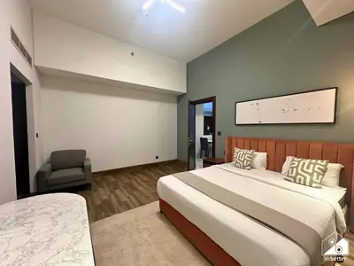 a bedroom with a large bed and a chair at Chic 1BR in Business Bay l Pool, Gym & Sauna in Dubai