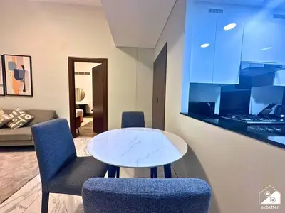 a living room with a table and two chairs at Chic 1BR in Business Bay l Pool, Gym & Sauna in Dubai