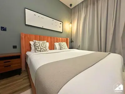 a bedroom with a large bed with white sheets at Chic 1BR in Business Bay l Pool, Gym & Sauna in Dubai