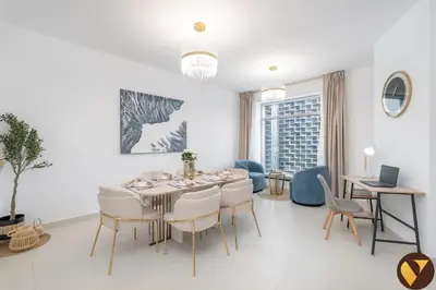 a white dining room with a table and chairs at Vogue Downtown The Lofts near Burj Khalifa and Dubai Mall, Two Bedroom Apartment with Balcony and City Skyline View, Access to all Amenities in Dubai