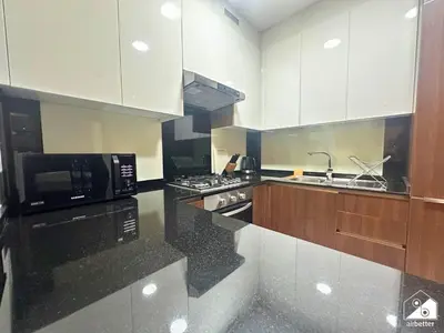 a kitchen with white cabinets and black counter tops at Stylish 1BR Stay l Rooftop Pool, Sauna & Gym in Dubai