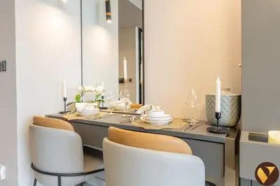 a dining room with a table with chairs and a mirror at Vogue Downtown Mag 318 near Burj Khalifa and Dubai Mall, Studio Apartment with Balcony, Canal and City View, Access to all Amenities in Dubai