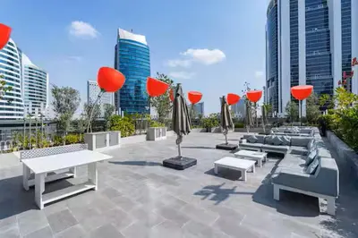 a patio with couches and tables in a city at Vogue Downtown Mag 318 near Burj Khalifa and Dubai Mall, Studio Apartment with Balcony, Canal and City View, Access to all Amenities in Dubai
