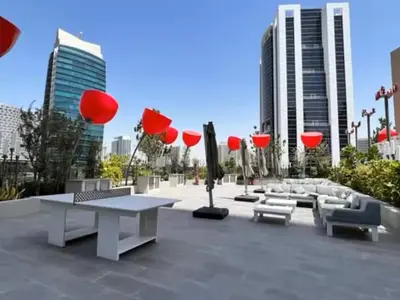 a park with tables and chairs and red umbrellas at Vogue Downtown Mag 318 near Burj Khalifa and Dubai Mall, Studio Apartment with Balcony, Canal and City View, Access to all Amenities in Dubai