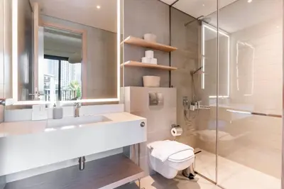 a bathroom with a toilet and a sink and a shower at New Luxury 2 Bedroom with Padel Gym Pool Cinema BBQ in Dubai