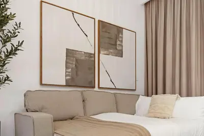 a living room with a couch and two pictures at Mahogany 16 - 1BR 4 Guests - Walk to Burj Khalifa in Dubai