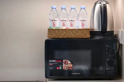 a couple of bottles of water sitting on top of a microwave at Mahogany 15 - 1BR 4 Guests - Walk to Burj Khalifa in Dubai