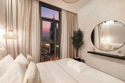 a bedroom with a white bed and a large window at Mahogany 15 - 1BR 4 Guests - Walk to Burj Khalifa in Dubai