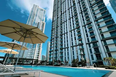 a large apartment building with a swimming pool and two umbrellas at Mahogany 15 - 1BR 4 Guests - Walk to Burj Khalifa in Dubai