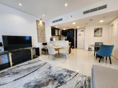 a living room with a tv and a table and chairs at Modern Monastery 1 BR Business Bay in Dubai