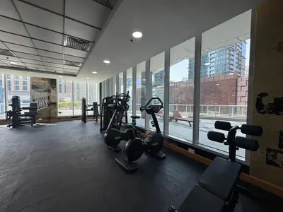 a gym with treadmills and machines in front of a window at Exclusive Torch Tower Penthouse In Dubai Marina in Dubai