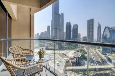 a balcony with chairs and a table with a view of the city at Luxury Studio Burj Khalifa View Address Dubai Mall in Dubai