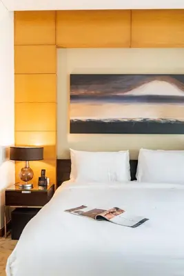a hotel room with a white bed and a painting at Luxury Studio Burj Khalifa View Address Dubai Mall in Dubai