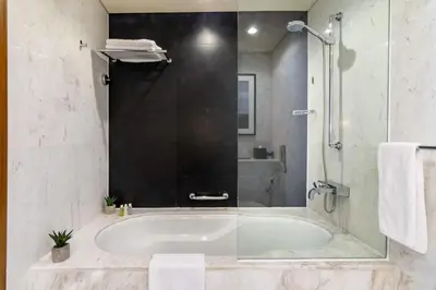a bathroom with a tub and a glass shower at Luxury Studio Burj Khalifa View Address Dubai Mall in Dubai