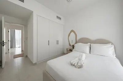 a white bedroom with a large white bed with a mirror at Luxury Villa 3BR with garden in Dubai