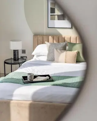 a bed with a tray with a cup on it at 1 Bedroom lagoon by District One in Dubai